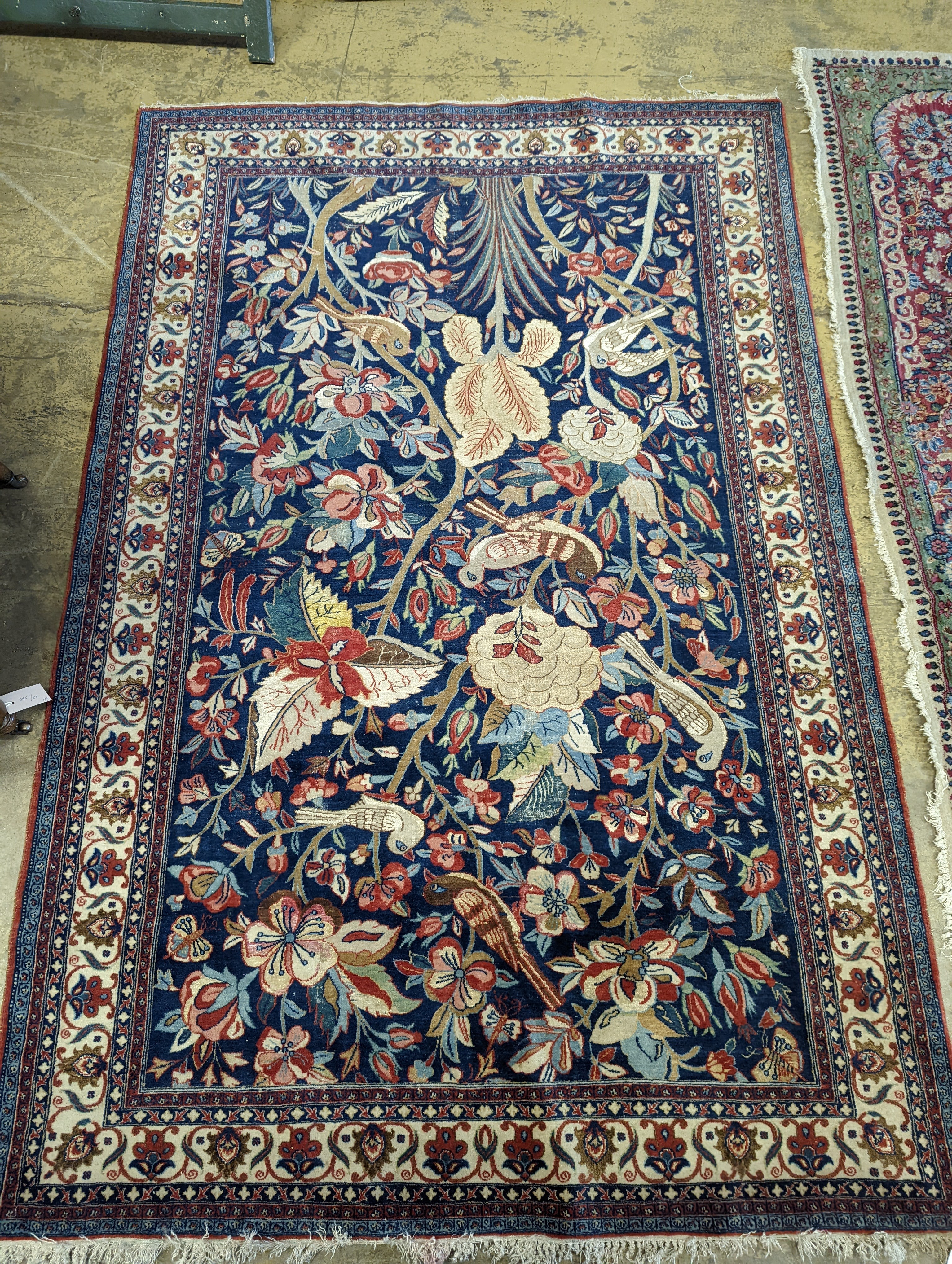 A Kirman blue ground rug woven with birds amongst flowering branches, 205 x 136cm